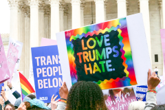"Love Trumps Hate" Rainbow and "Trans People Belong" signs in front of Supreme Court entrance